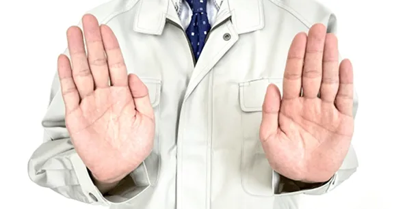 作業着を着た人物が両手を前に出していらないポーズをしています